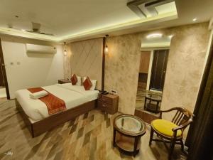 瓦拉纳西Trimrooms Banaras Station的一间卧室，里面有一张床、一张桌子和一把椅子