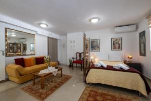 a bedroom with a bed and a living room at Myrto lower ground floor studio in Kalamata
