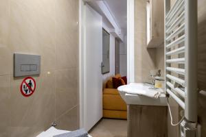 a bathroom with a sink and a yellow couch at Myrto lower ground floor studio in Kalamata +54 photos