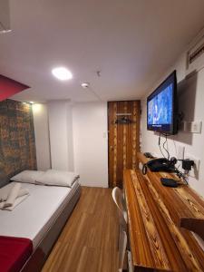 a bedroom with a bed and a television on a table at El Grande Inn Piy Margal Sampaloc Manila in Manila +13 photos