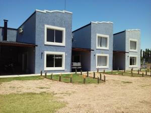 una casa azul con una valla delante en Complejo Las Cortaderas, en San Rafael