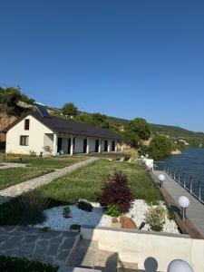 a house with a walkway next to the water at Casa Elaria in Sviniţa +14 photos