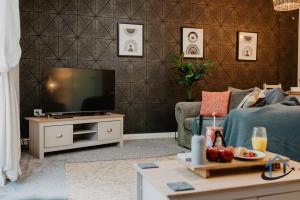 a living room with a television on a table at 4 Clovelly Court, Derby, DE22 1GS in Derby