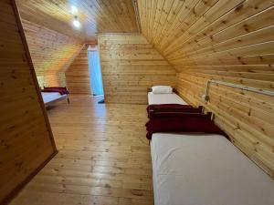 a room with two beds in a wooden cabin at Mirjana Guesthouse in Pukë
