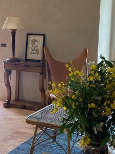 a chair and a table with a vase of flowers at La Terrazza di Rivoria - Vue magique & Terrasse in Masera +34 photos