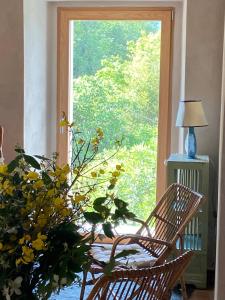 a room with a chair and a large window at La Terrazza di Rivoria - Vue magique & Terrasse in Masera