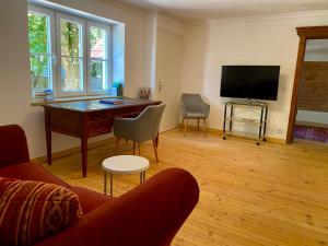 a living room with a desk and a tv at Kap der guten Hopfung in Absberg