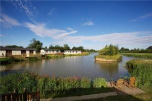 a view of a river with houses in the background at Wentworth Lodge in Tydd Saint Giles