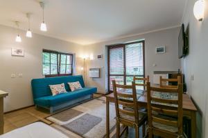 ein Wohnzimmer mit einem blauen Sofa und einem Tisch in der Unterkunft Apartamenty Zakopane Droga na Bystre 4A in Zakopane