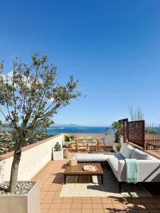 un patio avec un canapé, une table et un arbre dans l'établissement Begur Sunset 2 bedroom loft close to the center of Begur. With terrace and gorgeous sea views H42, à Begur