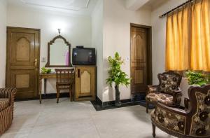 a living room with a tv and a chair at Hotel Sun Shine in New Delhi