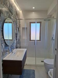 Un baño con lavabo, ducha y espejo. en Agrigento tra templi e mare 2, en Agrigento 13 fotos más
