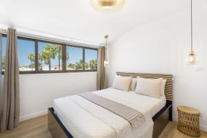 コスタ・デル・シレンチオにあるA T Suite Costa del Silencioの窓付きのベッドがある白い寝室 +14枚の写真
