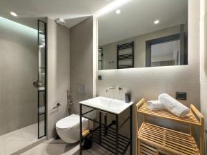 a bathroom with a sink and a toilet and a mirror at TWO ENTIRE APARTMENTS LIV Luxury Central C-D in Thessaloniki +23 photos