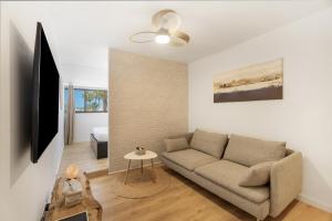 コスタ・デル・シレンチオにあるA T Suite Costa del Silencioのソファとテーブルのあるリビングルーム