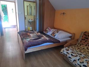 a small bedroom with a bed and a mirror at Domek Miodu mi daj in Wisła