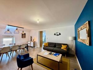 a living room with a couch and a table at L'Appart des Copains, beau duplex & centre-ville in Gérardmer +5 photos