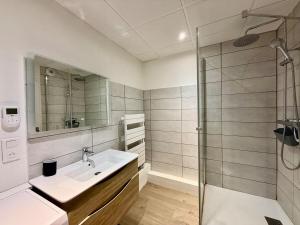 a bathroom with a sink and a shower at L'Appart des Copains, beau duplex & centre-ville in Gérardmer