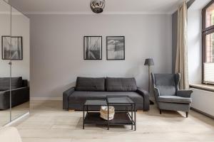 a living room with a couch and a chair at Good Weather Apartment in Poznań