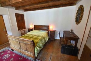 a bedroom with a bed and a table and a desk at Cò di Nóni, Ponto Valentino in Ponto Valentino