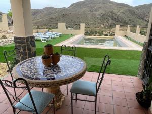 a table and chairs on a patio with a view at Cortijo del Humo in Mizala