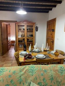 a dining room with a wooden table with plates on it at Cortijo del Humo in Mizala +13 photos