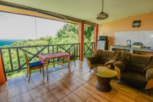 ein Wohnzimmer mit einem Balkon mit einem Tisch und Stühlen in der Unterkunft Sairee View Resort in Ko Tao