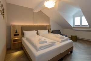 a bedroom with a large bed with white sheets at BERGlässig Hotel Bodenmais - 360 Grad Urlaub in Bodenmais