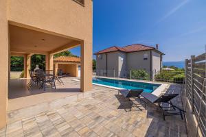 a patio with chairs and a pool in a house at Villa NOOK in Risika +33 photos