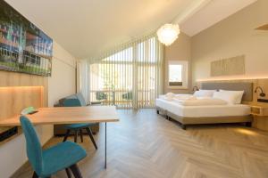 a bedroom with a bed and a desk and a table at BERGlässig Hotel - Halbpension Plus inkl Getränke in Bodenmais
