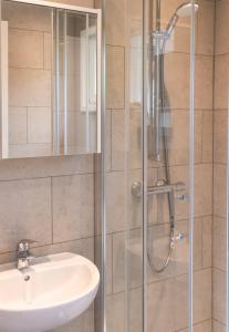 a bathroom with a sink and a shower at Chalet met hottub & omheinde tuin Zeeland VP090 in Heinkensand