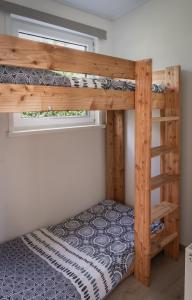a bunk bed in a small room with a window at Chalet met hottub & omheinde tuin Zeeland VP090 in Heinkensand +33 photos
