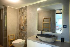 a bathroom with a sink and a toilet and a mirror at Cestrum Suites in Agios Nikolaos +61 photos
