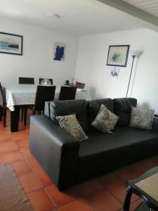 a black couch in a living room with a table at Casa Dos Mosteiros in Mosteiros