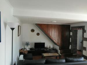 a living room with a couch and a staircase at Casa Dos Mosteiros in Mosteiros