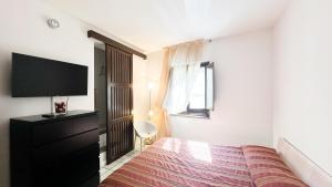 a bedroom with a bed and a flat screen tv at Le camere di Vicoli e Mare in Maratea