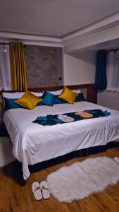 a bedroom with a large bed with yellow and blue pillows at Davida Getaway in Gatunga +3 photos