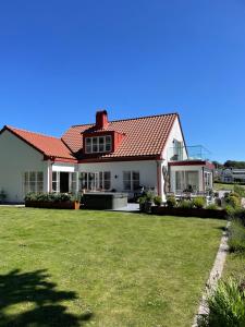 a house with a red roof and a yard at Villa Lysholmen in Särö