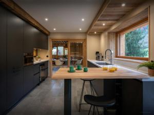 a kitchen with a large wooden island in the middle at Chalet La Parenthèse - OVO Network in Samoëns