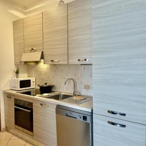 a kitchen with a sink and a microwave at Bnbook Emozione Lago in Dormelletto +23 photos