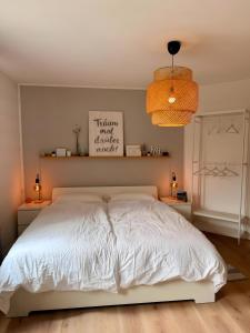 a bedroom with a white bed and two lamps at Lieblingszeit bei Bamberg in Hirschaid