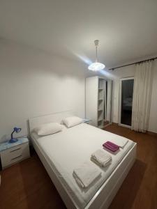 a bedroom with a white bed with towels on it at Apartments Anđelka in Pag