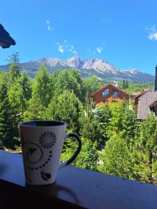 eine Kaffeetasse auf einem Fensterbrett mit Aussicht in der Unterkunft Kukučka Lomnica - Tatranská Lomnica in Tatranská Lomnica