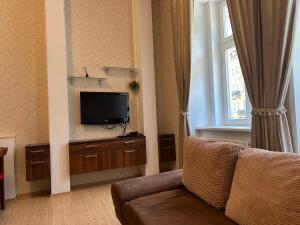 ein Wohnzimmer mit Couch und Flachbildfernseher in der Unterkunft Apartment Sadova Karlovy Vary in Karlsbad