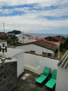 two green chairs on the roof of a building at Casa Dos Mosteiros in Mosteiros