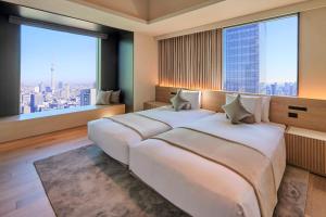a large white bed in a room with large windows at The Royal Park Hotel Iconic Tokyo Shiodome in Tokyo