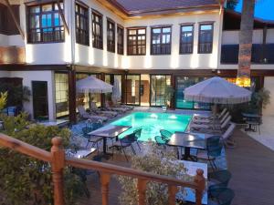 a house with a swimming pool with tables and chairs at Belmondo Suites Old Town Antalya in Antalya