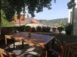 a wooden table on a patio with a view of the water at Beautiful apartment-center of old town in Cavtat in Cavtat