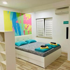 a bedroom with two blue pillows on a bed at City Center Sweet Apartment in Niš