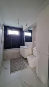 een badkamer met toilet, bad en wastafel bij Apt blisko morza in Kosakowo +7 foto's